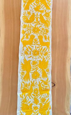 a yellow and white table runner with birds on it