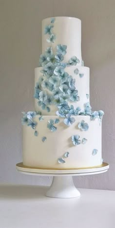 a three tiered cake with blue flowers on it