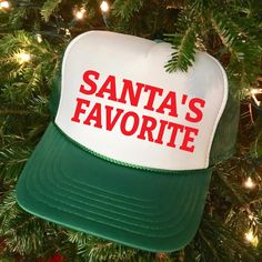 Christmas Trucker Hat, Christmas Hat, Christmas Apparel, Christmas Gift, Santa's Favorite How to Place an Order 1.  Review Product Photos Please examine and review the product photos provided.  2.  Select Hat Color Choose your preferred color for the hat. 3. Choose Design Select the design you desire. 4. Personalize Your Hat Add your personalization details.  5. Add to Cart Click "Add To Cart" to proceed. 6. Continue Shopping Feel free to return to add more products or proceed to checkout.   Pro Green Novelty Hat For Gift, Green Novelty Hat As A Gift, Green Novelty Hat As Gift, Fun Adjustable Christmas Hats, Adjustable Christmas Hat As Gift, White Christmas Hat As Gift, White Christmas Holiday Hat, White Christmas Cap, Trucker Hat Designs