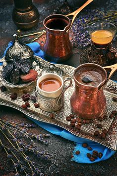 two cups of tea sit on a tray with spoons next to some other items