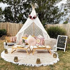 a teepee is set up in the yard with pillows and other items on it