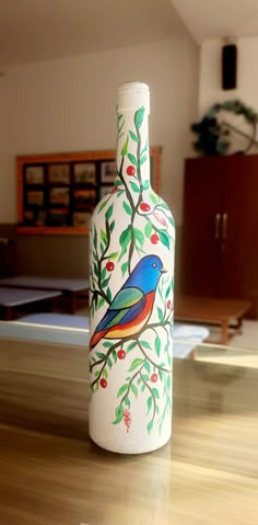 a painted bottle sitting on top of a wooden table