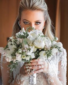 a woman holding a bouquet of flowers in front of her face