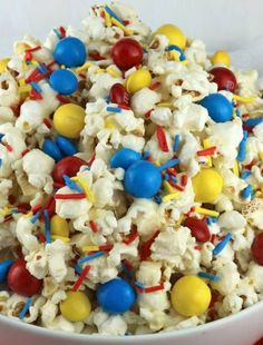 a white bowl filled with popcorn covered in m & m candies