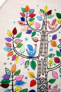 an embroidered tree with colorful leaves and birds