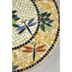 a mosaic table with dragonflies and leaves on it