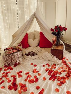 a bed with red petals on it and a canopy over the headboard that is open