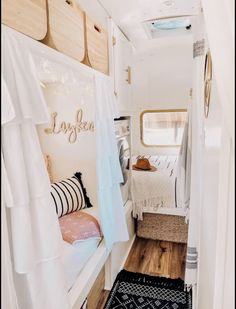 the interior of a camper with white walls and wood flooring