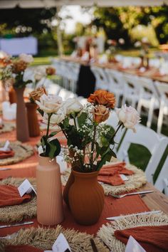 several vases filled with flowers sitting on top of a table