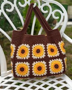 a crocheted brown and yellow purse sitting on top of a white plastic chair