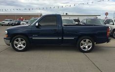 a blue pick up truck parked in a parking lot