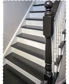 a black and white staircase with wooden handrails