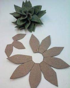 some paper flowers and a plant on a white table with it's petals cut out to look like leaves