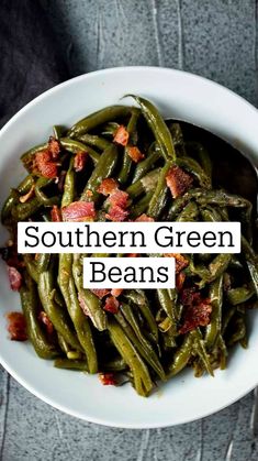 cooked green beans with bacon in a white bowl on a gray tablecloth, ready to be eaten