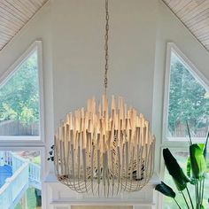 a chandelier made out of bamboo sticks hanging from the ceiling in a living room