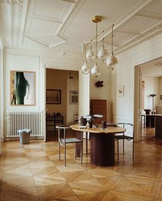 an elegant dining room with wooden floors and chandelier hanging from the ceiling,