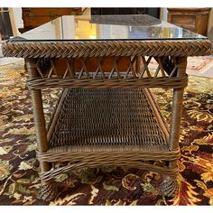 a wicker coffee table with glass top in a living room or dining room area