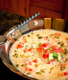 a bowl filled with soup on top of a counter next to a knife and spoon