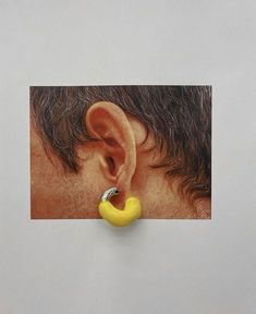 an ear with a banana attached to it's side, in front of a white background