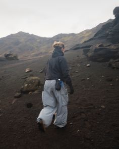 a man walking on top of a dirt field