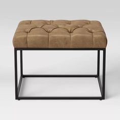 a brown leather bench with metal frame legs and an upholstered seat cushion on top