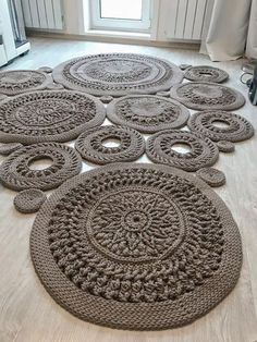 several circular rugs on the floor in front of a window