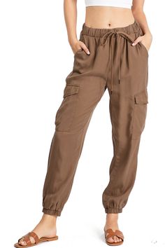 Light weight jogger pants with a high rise fit, a stretchy waist and an adjustable drawstring. Pockets at the sides and oversized pockets down the leg. Tapered elasticized ankle length. Baggy and comfortably fit. CARE | Hand Wash ColdCONTENTS | 100% Tencel MEASUREMENTS | 38"/97 cm Top to Bottom 26"/66 cm Inseam 12"/31 cm Rise (Size Small) MODEL | 5'8 - wearing a size SmallIMPORTED Women Jogger Pants, Casual Joggers, Short Denim Skirt, Lightweight Pants, Fitted Joggers, Cargo Joggers, Women Cargos, Cargo Pant, Joggers Womens