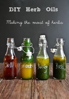 four bottles with different colored liquids in them on a table next to a chalkboard