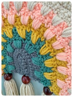 a crocheted blanket with tassels and beads