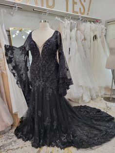 a dress on display in a store with dresses and gowns hanging up behind it