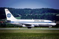 a pan am airplane is on the runway at an airport in front of some trees