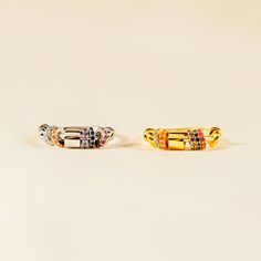 two different colored rings sitting next to each other on top of a white surface,