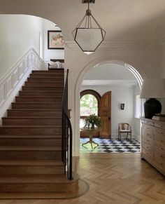 an entry way leading to a living room and dining room with wood flooring on the side