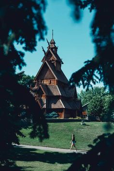 a person walking in front of a large wooden building with a steeple on top