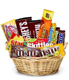 a wicker basket filled with assorted candy bars and snacks on a white background