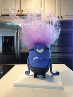 a blue and purple minion sitting on top of a counter