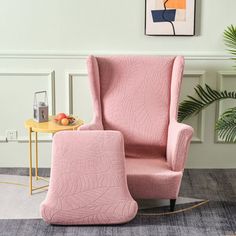 a pink chair and footstool in a room with a painting on the wall