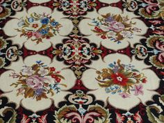 an area rug with many different designs and colors on the carpet, including flowers in red, blue, green, yellow and white