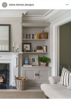 a living room filled with furniture and a fire place in front of a mirror on the wall