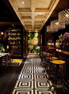 the interior of a restaurant with tables, chairs and chandeliers hanging from the ceiling