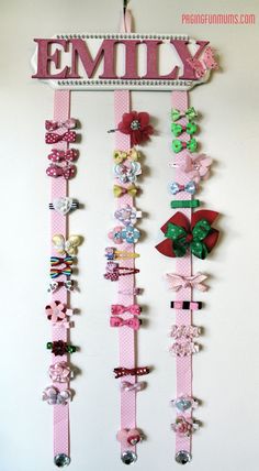 a wall hanging made out of pink and green hair clips with the word family on it