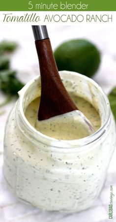 an avocado ranch in a jar with a wooden spoon sticking out of it