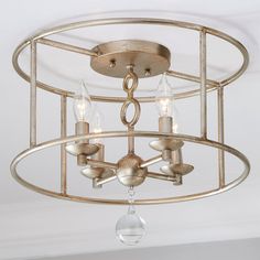 a chandelier with three lights hanging from it's center circle, in a white room