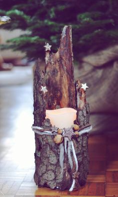 a candle is sitting in the middle of a tree stump with stars on it and ribbon