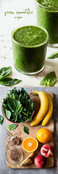 green smoothie with fruits and vegetables on a cutting board next to a bowl of spinach