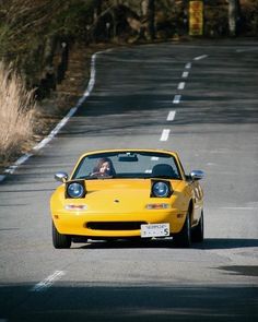 a yellow sports car driving down the road