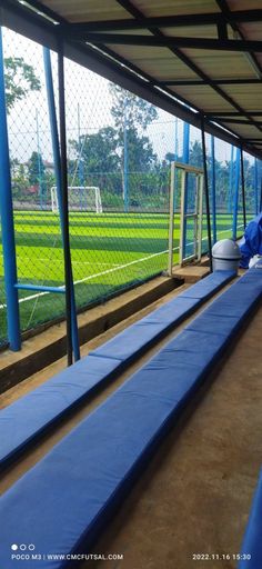 the inside of a baseball dugout with blue seats