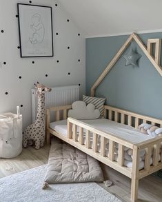 a baby's room with blue walls and white carpeted flooring, a wooden cot in the shape of a house