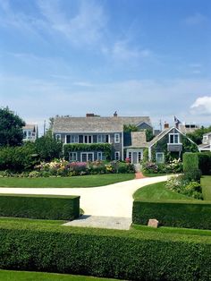 a large house surrounded by lush green hedges