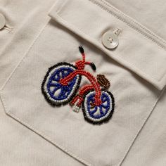 a close up of a button on a white shirt with a bike embroidered on it